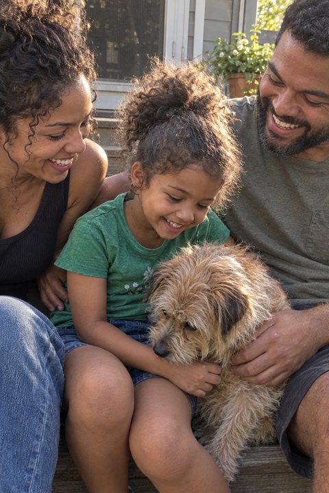 Example photo: Maya on the back steps with her mom, dad and dog